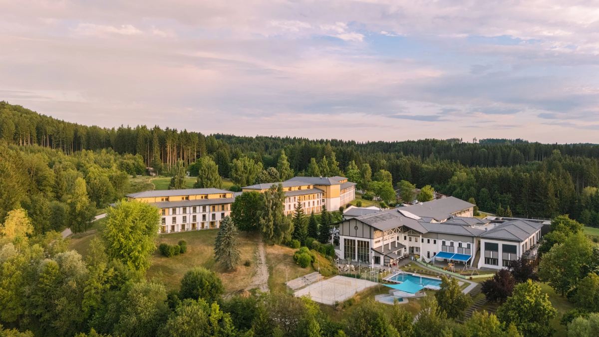 Aldiana Club Ampflwang zwischen Wald und Hügeln, im Vordergrund der Außenpool