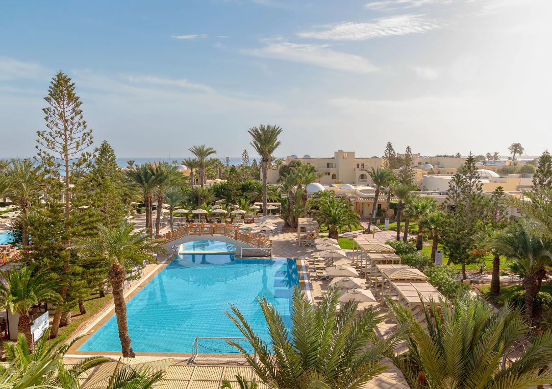 Pool zwischen Palmen und Liegen im Aldiana Club Djerba Atlantide
